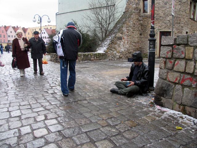 Żebranie Cygana z komórką w kieszeni