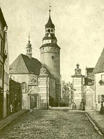Schildauerstrasse w latach 30. ubiegłego wieku. Dziś w krajobrazie ulicy nie ma już wiszącego zegara oraz tramwajów.