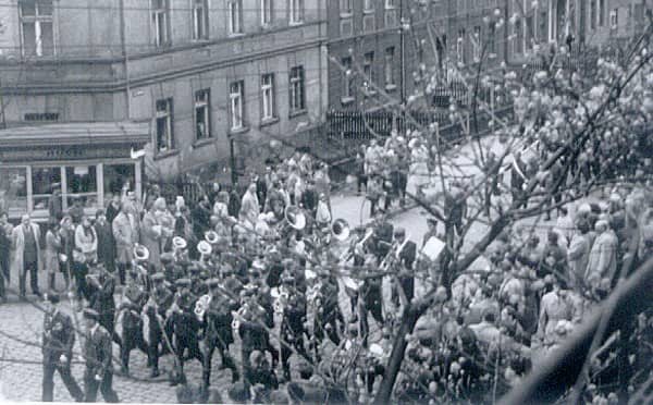 Lata 70-te. Pochód przechodził wówczas ulicą Złotniczą. Uczeń z prawej, oprócz napisu z nazwą szkoły, trzyma parasolkę. Na szczęście nie padało.