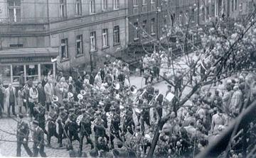 Lata 70-te. Pochód przechodził wówczas ulicą Złotniczą. Uczeń z prawej, oprócz napisu z nazwą szkoły, trzyma parasolkę. Na szczęście nie padało.