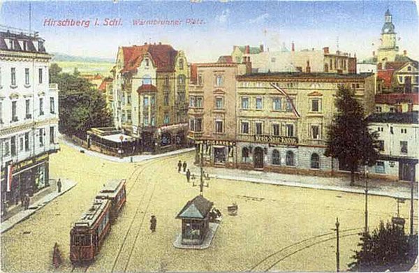 Warmbrunnerplatz z perspektywy okna okolicznych kamienic. Widoczny przystanek tramwajowy z kioskiem i po prawej – budka meteorologiczna.