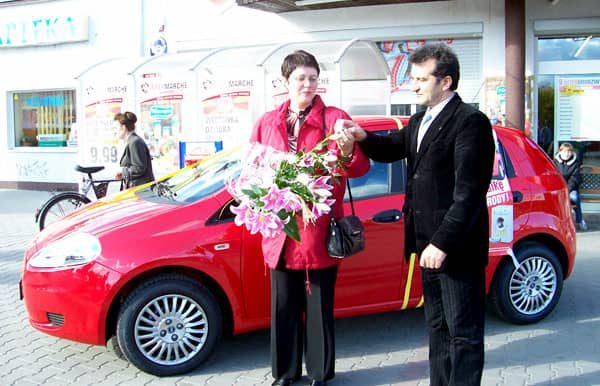 J. Anioła wręcza Elżbiecie Maśluk kluczyki do czerwonego Fiata Grande.