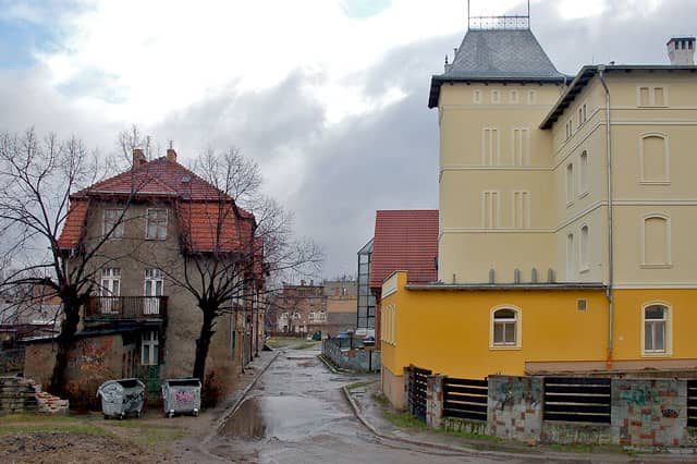 Błyszczący jeden z budynków uzdrowiska i zszarzałe oraz brudne kamienice: to codzienność w Cieplicach.