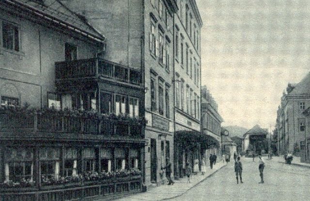 Tej werandy ani kamienicy po lewej stronie zdjęcia już nie ma. W ich miejscu stoi część nowego Domu Zdrojowego. Dalsze budynki zachowały się niemal bez zmian. W jednym z nich pozos