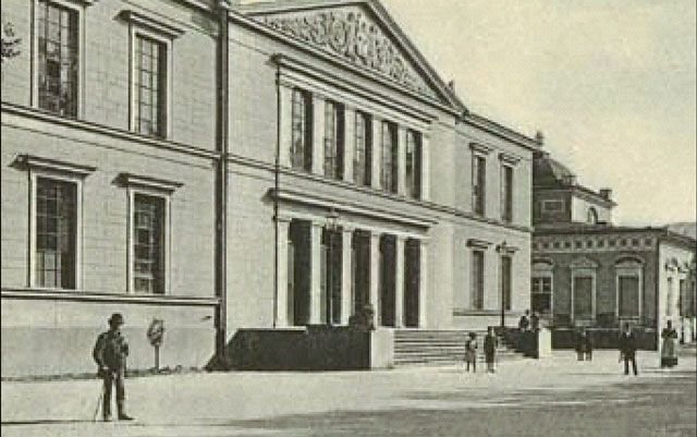 Teatr Zdrojowy (w tle Galeria). Kuracjusze z uwagą przypatrują się fotografowi. To jedno ze starszych zdjęć obrazujących dawne Cieplice.