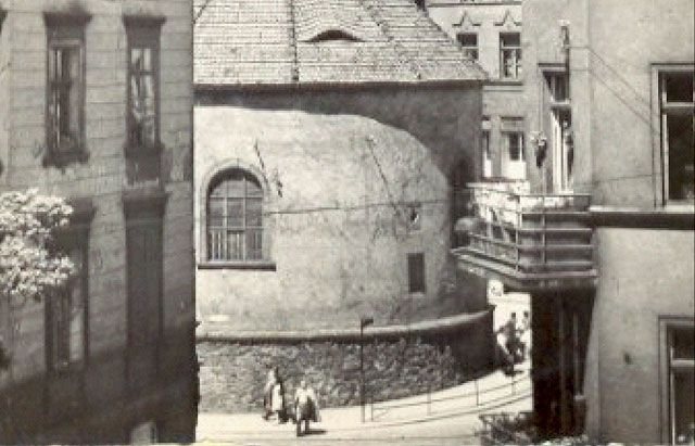 Początek ulicy Bankowej sfotografowany z okien kamienicy na Piłsudskiego. Widoczne barierki chroniące przed wejściem na torowisko oraz światło ostrzegające przed zbliżającym się tr