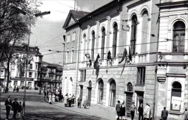 To samo miejsce jeszcze przed remontem elewacji. Na fotografii uwieczniono powrót manisfestantów z pochodu pierwszomajowego.