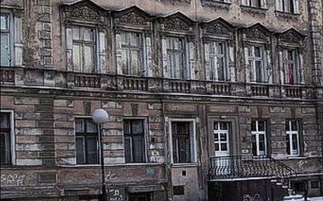 Kamienica mieszkalna przy ul. 1 Maja. Ktoś „zepsuł” bryłę budynku dobudowując schodki i wybijając drzwi na parterze.