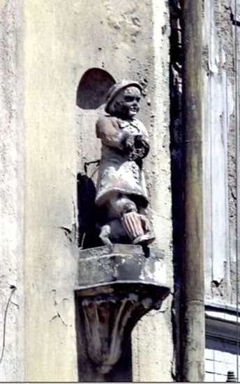 „Trzymacz” latarni bez latarni na fasadzie domu aktora: brak troski o śródmiejskie kamienice odczuły boleśnie piękne, architektoniczne detale. Dziś figurka jest odnowiona.