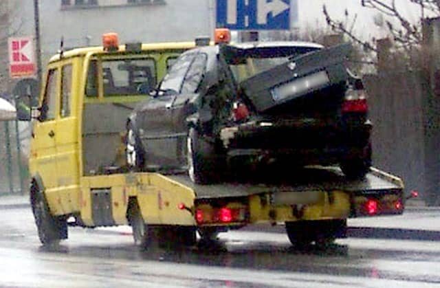Pomoc drogowa odwozi uszkodzone auto na parking.