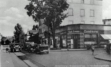 Róg Hindenburgstrasse i Franzstrasse (1 Maja i Okrzei) oraz popularna kawiarnia i cukiernia Zimmera (dziś bar Karzełek). I zagadka: dlaczego zamurowano okna w pobliskiej kamienicy?