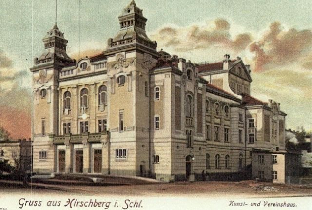 Patrząc na teatr oglądamy zapadające w pamięci widowisko dzięki potężnym maskom secesyjnym na frontonie. Obrazek uwieczniony krótko po zakończeniu budowy. Widać jeszcze resztki mat