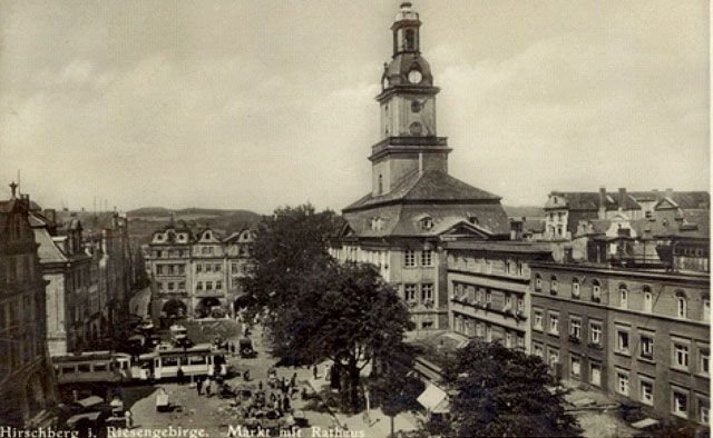 Przed ratuszem zielenią się kasztanowce, tramwaj z wagonem doczepnym zmierza w stronę placu Cieplickiego. Na rynku – stoiska handlowe. Pełnia życia w centrum miasta. Przełom lat 20