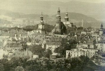 Miasto w czerni i bieli: cztery wieże i Karkonosze w tle.