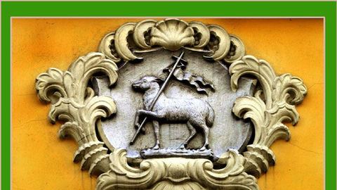 Fasada jednej z kamienic przy ul. 1 Maja z płaskorzeźbą przedstawiającą symbol Chrystusa – Baranka Paschalnego. Skąd ten ornament? Kamienice w tej części miasta były budowane przez