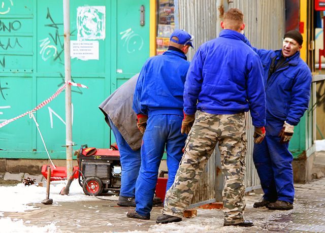 Robotnicy zagradzają przyszły teren budowy.
