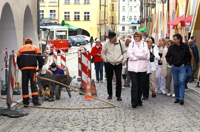 Niemieccy turyści zwiedzają miasto przy ogłuszającym huku młotów pneumatycznych.