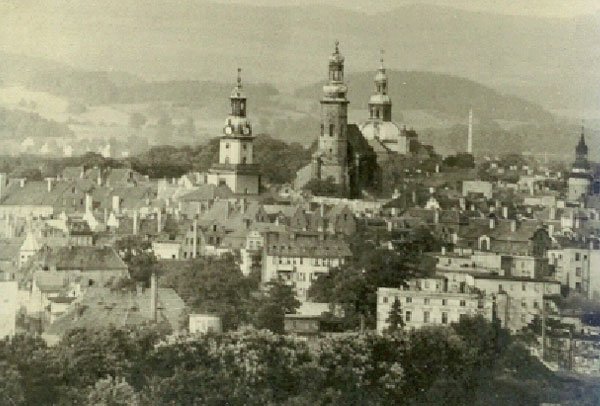 Miasto w czerni i bieli: cztery wieże i Karkonosze w tle.