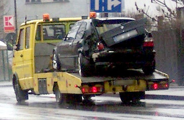 Pomoc drogowa odwozi uszkodzone auto na parking.