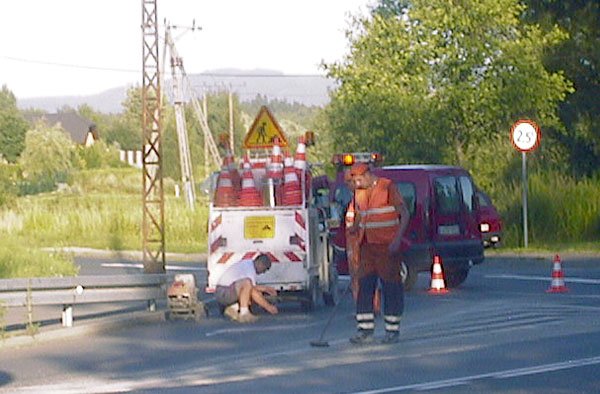 Ekipy drogowców przygotowują nawierzchnię jezdni do pomalowania.