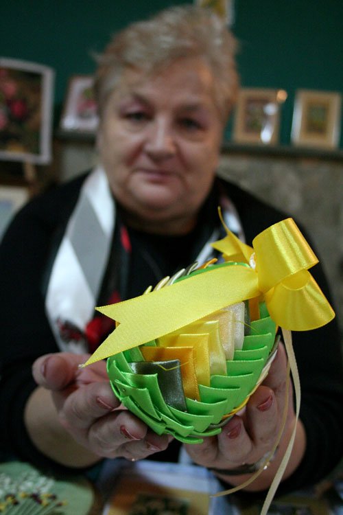 Ewa Kokoszka prezentuje pisankę wykonaną metodą wstążeczkową.