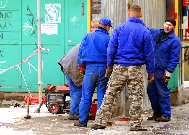 Robotnicy zagradzają przyszły teren budowy.
