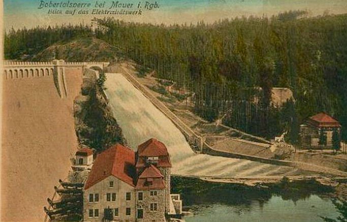 Próg wodny przy wyższym stanie. Hydroelektrownia na pierwszym planie.