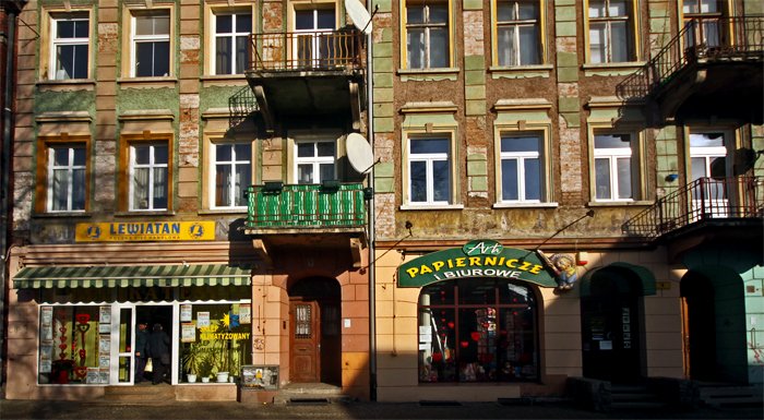 Sklepy na placu Piastowskim. Spod tynku wyglądają szyldy dawnych spożywczaków.