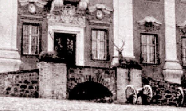 Archiwalna fotografia pałacu w Maciejowej z jeleniami przy wejściu.