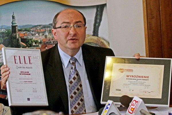 Prezydent Marek Obrębalski pokazuje dyplomy wyróżnień, które Jelenia Góra zdobyła ostatnio za akcje promocyjne miasta, w tym tę popularyzującą szlaki rowerowe: