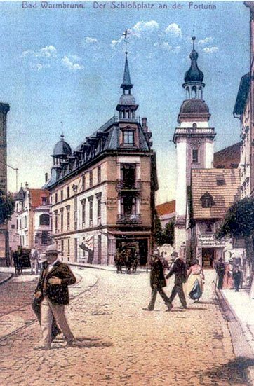Belle epoque na Schlossplatz. Przed dzwonnicą kościoła św. Jana Chrzciciela nieisteniejące już dziś zabudowania. Zostały wyburzone pod budowę domu zdrojowego.