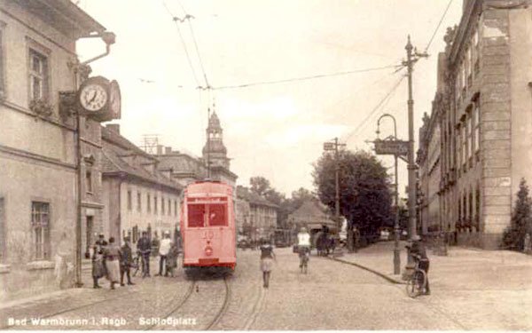 To samo miejsce innego dnia i nieco później. Nadjeżdża tramwaj. Dziś po stylizowanych żeliwnych słupach trakcyjnych nie ma śladu. Po zegarze też nic się nie ostało.