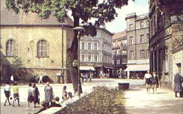 Mniej więcej to samo miejsce 170 lat później: lata 70-te przy alei 15 Grudnia. Pan widoczny po prawej wchodzi do szaletu, mniej chlubnej, ale potrzebnej w mieście placówki.