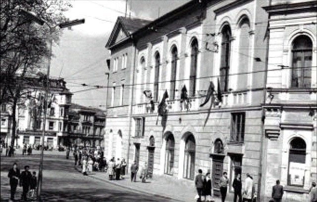 To samo miejsce jeszcze przed remontem elewacji. Na fotografii uwieczniono powrót manisfestantów z pochodu pierwszomajowego.