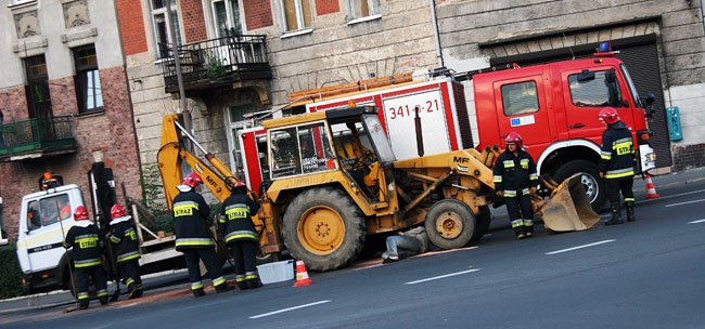 Strażacy sprzątają po niesprawnym pojeździe, z którego wyciekła toksyczna i niebezpieczna substancja.