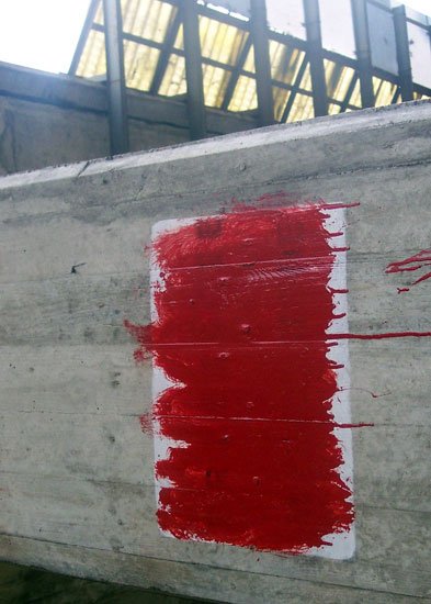Zamalowane ostrzeżenie przed niebezpieczeństwem pod estakadą.