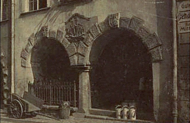 Statek symbol Konfraterni Kupieckiej. Zdjęty w latach 60-tych przy modernizacji kamienic na placu Ratuszowym. Można go obejrzeć w ogrodach Muzeum Karkonoskiego. W podcieniach – towar ze sklepu blacharskiego.