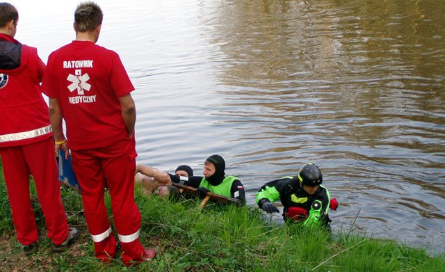 Strażacy wyciągają ofiarę z koryta Bobru.