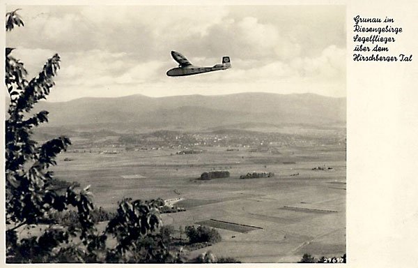 Szybowiec nad Jelenią Górą, w tle panorama Karkonoszy. Na ogonie ma swastykę. Pocztówka pochodzi z okresu po 1933 roku.