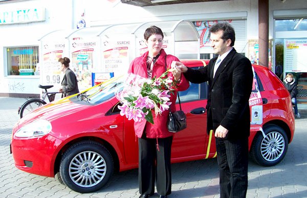 J. Anioła wręcza Elżbiecie Maśluk kluczyki do czerwonego Fiata Grande.