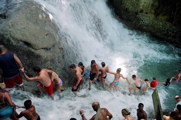 Dunn’s River Falls – turyści ubierają specjalne plastikowe sandały i za przewodnikiem, gęsiego maszerują w górę wodospadu.